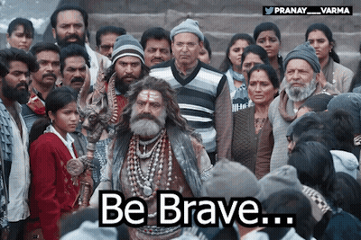 A Man With A Beard Stands In Front Of A Crowd With The Words Be Brave Written Below Him GIF