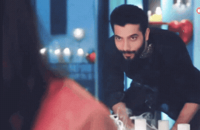 A Man With A Beard Stands In Front Of A Mirror GIF