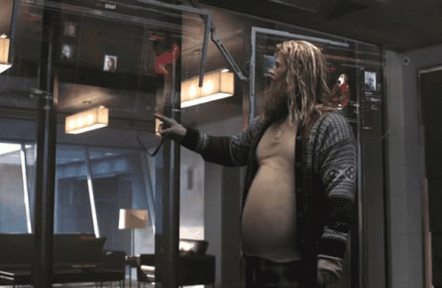 A Man With A Beard Stands In Front Of A Screen That Says 2013 GIF