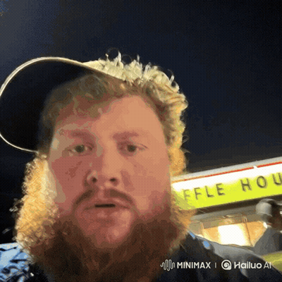 A Man With A Beard Stands In Front Of A Waffle House Sign GIF