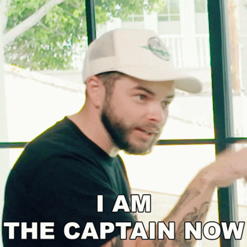 A Man With A Beard Wearing A Baseball Cap Says I Am The Captain Now GIF