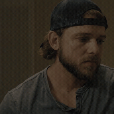 A Man With A Beard Wearing A Baseball Cap Says I 'Ll Be Back Soon GIF