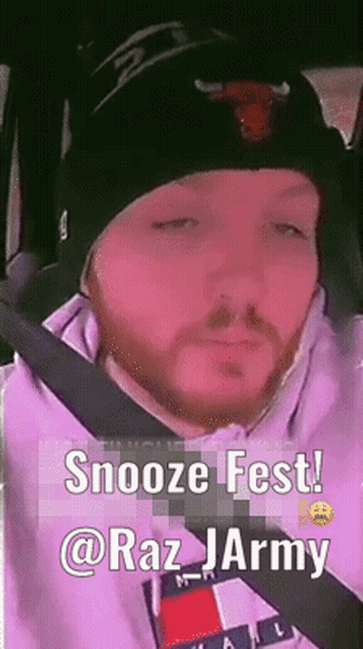 A Man With A Beard Wearing A Beanie And A Tommy Hilfiger Hoodie Is Sitting In A Car . GIF