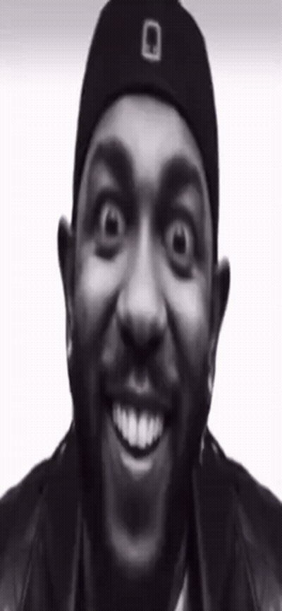 A Man With A Beard Wearing A Black Hat And A Black Jacket Is Smiling . GIF