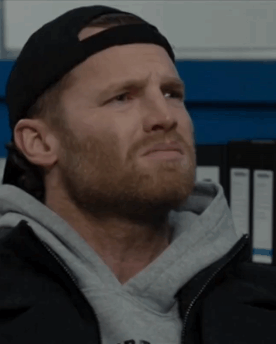 A Man With A Beard Wearing A Black Hat And A Grey Jacket GIF