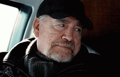 A Man With A Beard Wearing A Black Hat And Scarf GIF