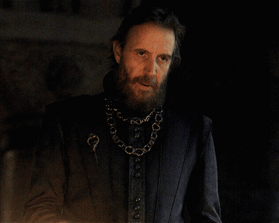 A Man With A Beard Wearing A Black Jacket And A Gold Chain Around His Neck GIF