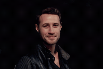A Man With A Beard Wearing A Black Shirt And A Black Leather Jacket GIF
