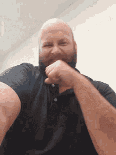 A Man With A Beard Wearing A Black Shirt Is Laughing GIF