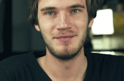 A Man With A Beard Wearing A Black Shirt Is Smiling GIF