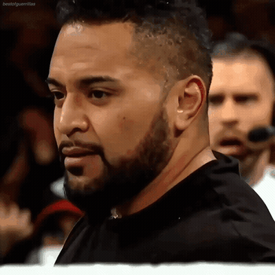 A Man With A Beard Wearing A Black Shirt Is Standing In A Crowd GIF