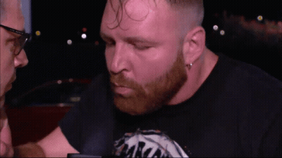 A Man With A Beard Wearing A Black Shirt That Says ' Aaron ' On It GIF
