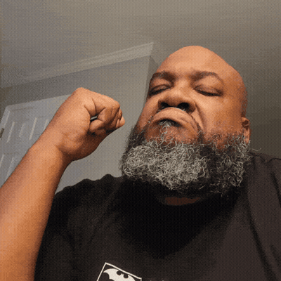 A Man With A Beard Wearing A Black Shirt With A Bat On It GIF