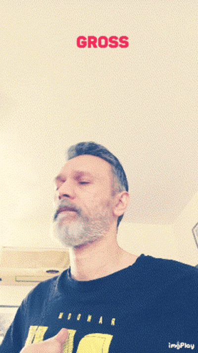 A Man With A Beard Wearing A Black Shirt With The Word Gross On It GIF