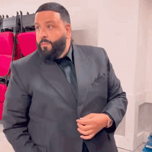 A Man With A Beard Wearing A Black Suit And Tie GIF