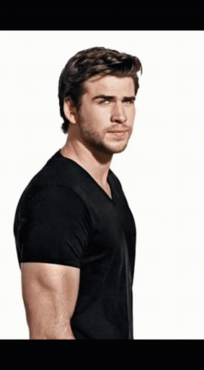 A Man With A Beard Wearing A Black T-Shirt Is Standing In Front Of A White Background GIF