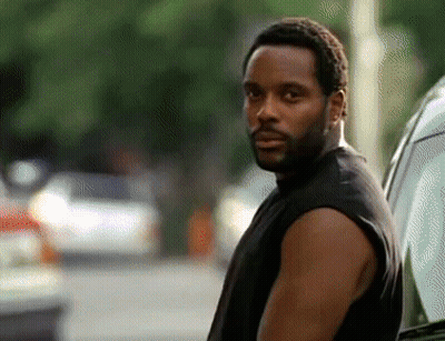 A Man With A Beard Wearing A Black Tank Top Is Standing Next To A Car GIF