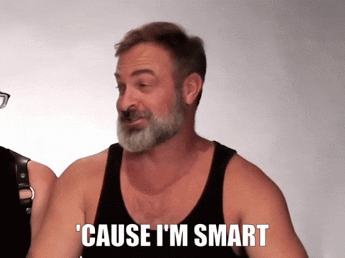 A Man With A Beard Wearing A Black Tank Top Says ' Cause I 'M Smart ' GIF