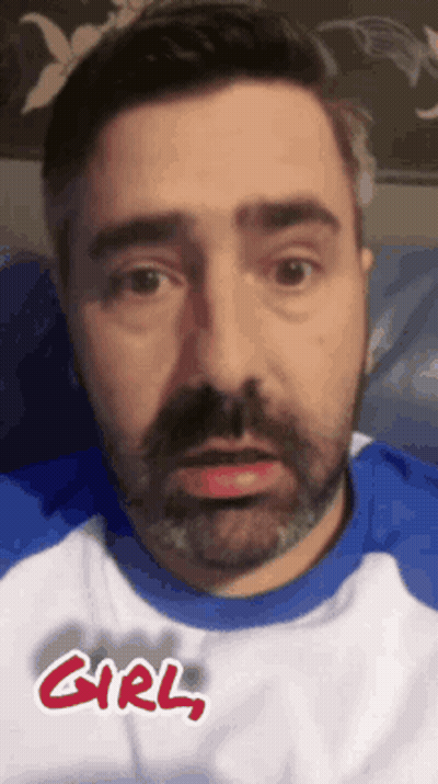 A Man With A Beard Wearing A Blue And White Shirt With The Word Girl Written On It . GIF