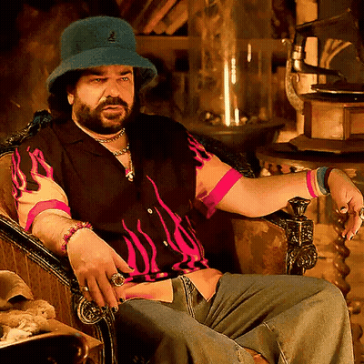 A Man With A Beard Wearing A Blue Hat And A Pink Shirt GIF