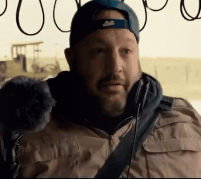 A Man With A Beard Wearing A Blue Hat And A Tan Jacket GIF