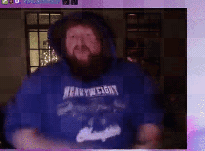 A Man With A Beard Wearing A Blue Heavyweight Hoodie Is Dancing . GIF