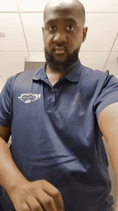 A Man With A Beard Wearing A Blue Polo Shirt That Says ' Velocity ' On It GIF