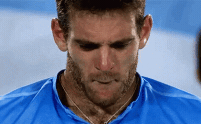 A Man With A Beard Wearing A Blue Shirt Is Looking Down . GIF