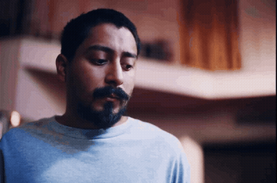 A Man With A Beard Wearing A Blue Shirt Looks Down GIF