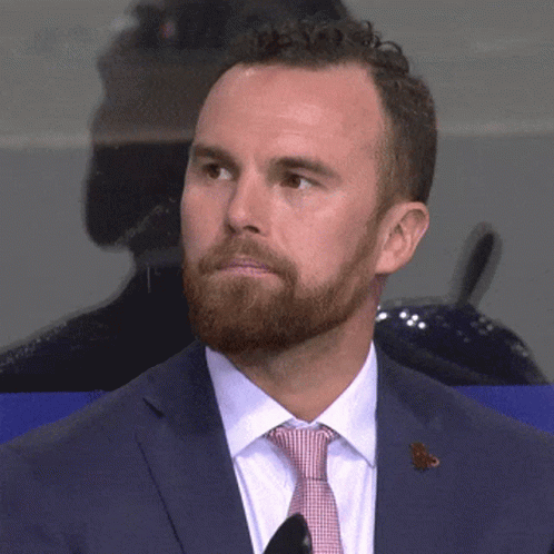 A Man With A Beard Wearing A Blue Suit And Tie GIF