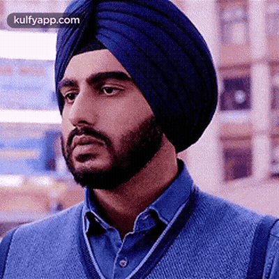 A Man With A Beard Wearing A Blue Turban And A Blue Sweater . GIF