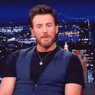 A Man With A Beard Wearing A Blue Vest And Black Shirt GIF