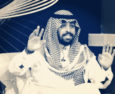 A Man With A Beard Wearing A Checked Scarf And A White Shirt GIF