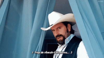 A Man With A Beard Wearing A Cowboy Hat And Vest Says Trop De Reveuh-T'illusoires GIF