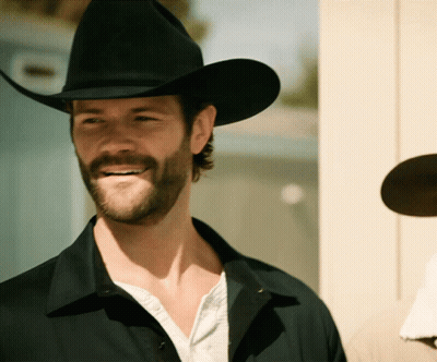 A Man With A Beard Wearing A Cowboy Hat Smiles GIF