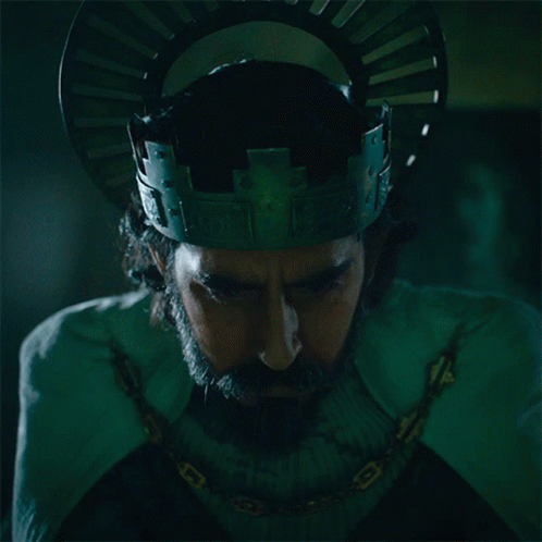 A Man With A Beard Wearing A Crown And A Chain Around His Neck GIF