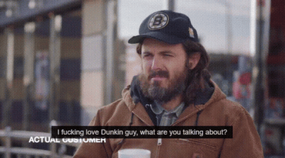 A Man With A Beard Wearing A Dunkin Donuts Hat Talks To Another Man GIF