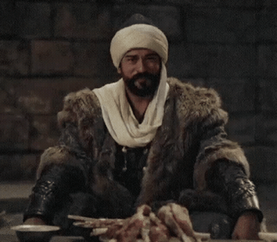 A Man With A Beard Wearing A Fur Coat And Turban . GIF