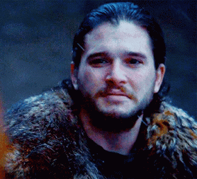 A Man With A Beard Wearing A Fur Coat Is Looking At The Camera . GIF
