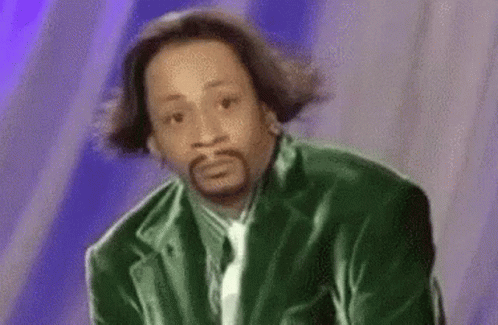 A Man With A Beard Wearing A Green Jacket And Tie Is Making A Funny Face . GIF