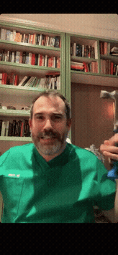 A Man With A Beard Wearing A Green Scrub Top With The Name Ricky On The Front Pocket GIF