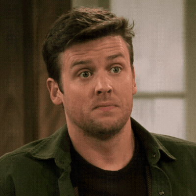 A Man With A Beard Wearing A Green Shirt And A Black Shirt GIF