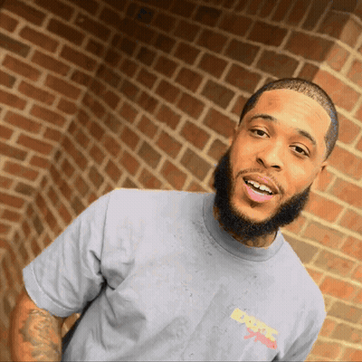 A Man With A Beard Wearing A Grey Shirt That Says Exotic Sports GIF