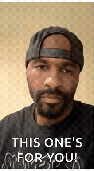 A Man With A Beard Wearing A Hat And A Black Shirt Says " This One 'S For You " GIF