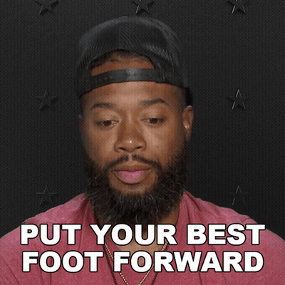 A Man With A Beard Wearing A Hat And A Red Shirt Says Put Your Best Foot Forward GIF