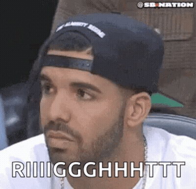 A Man With A Beard Wearing A Hat And A White Shirt Is Making A Face . GIF