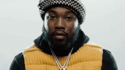 A Man With A Beard Wearing A Hat And A Yellow Vest . GIF