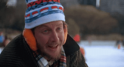 A Man With A Beard Wearing A Hat And Ear Muffs Is Smiling . GIF
