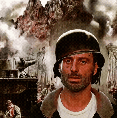 A Man With A Beard Wearing A Helmet In Front Of A Painting Of Soldiers GIF