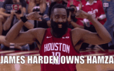 A Man With A Beard Wearing A Houston Jersey Is Flexing His Muscles . GIF